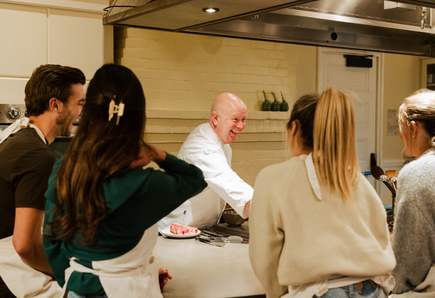 Chef smiling with group cooking school