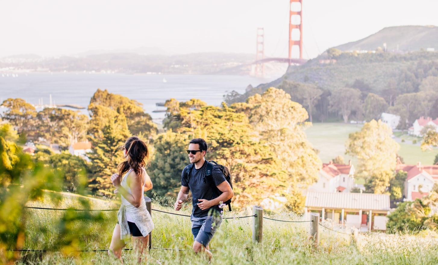couple hiking golden gate and property in background