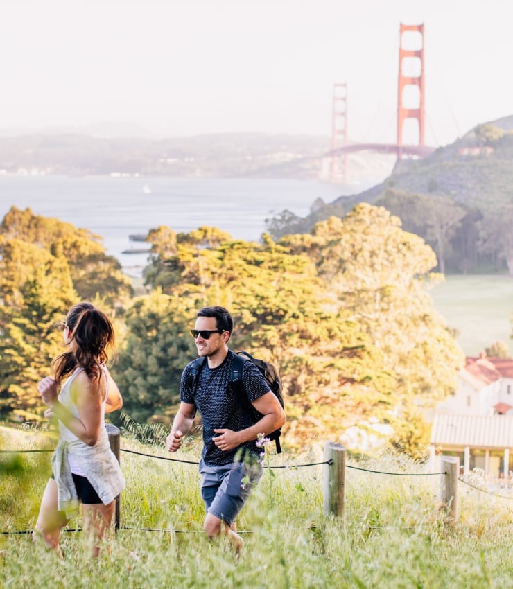 couple hiking golden gate and property in background