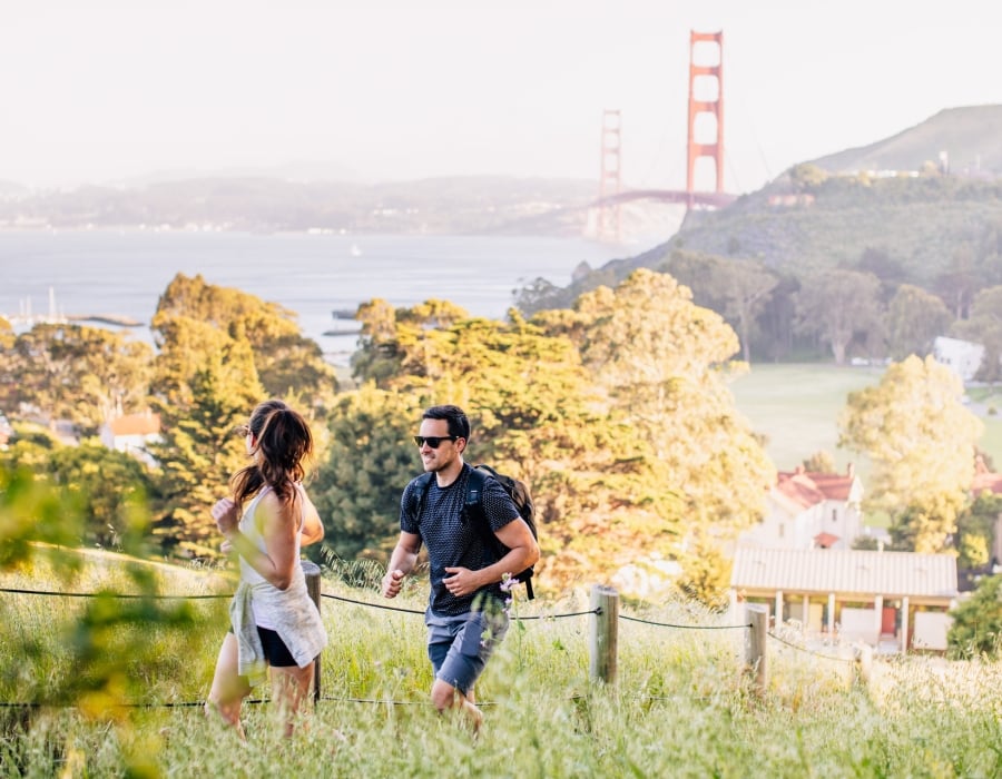 couple hiking golden gate and property in background