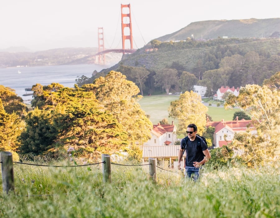 man hiking golden gate and property in background