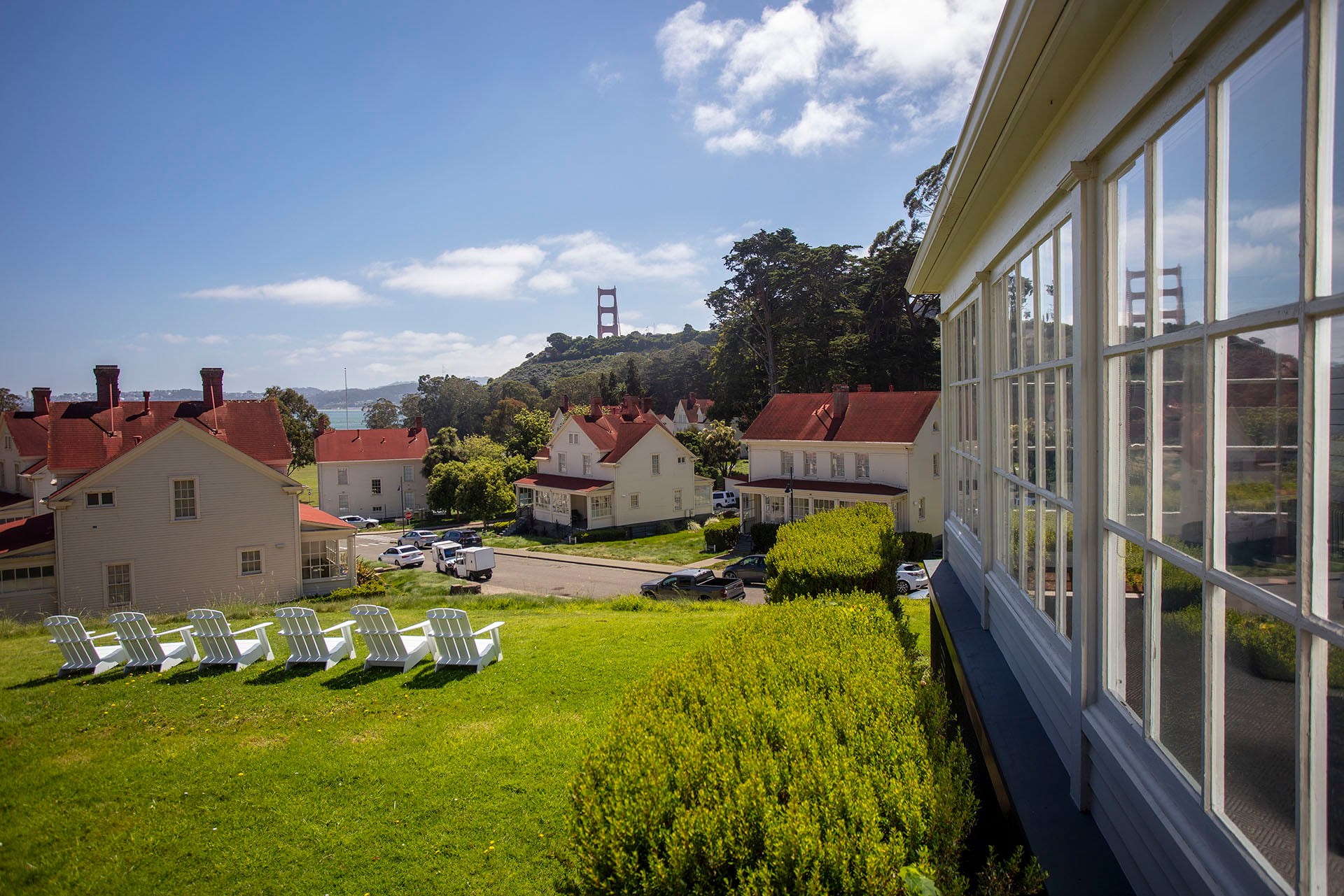 Lawn area with multiple white chairs overlooking buildings at Cavallo Point and the Golden Gate Bridge.