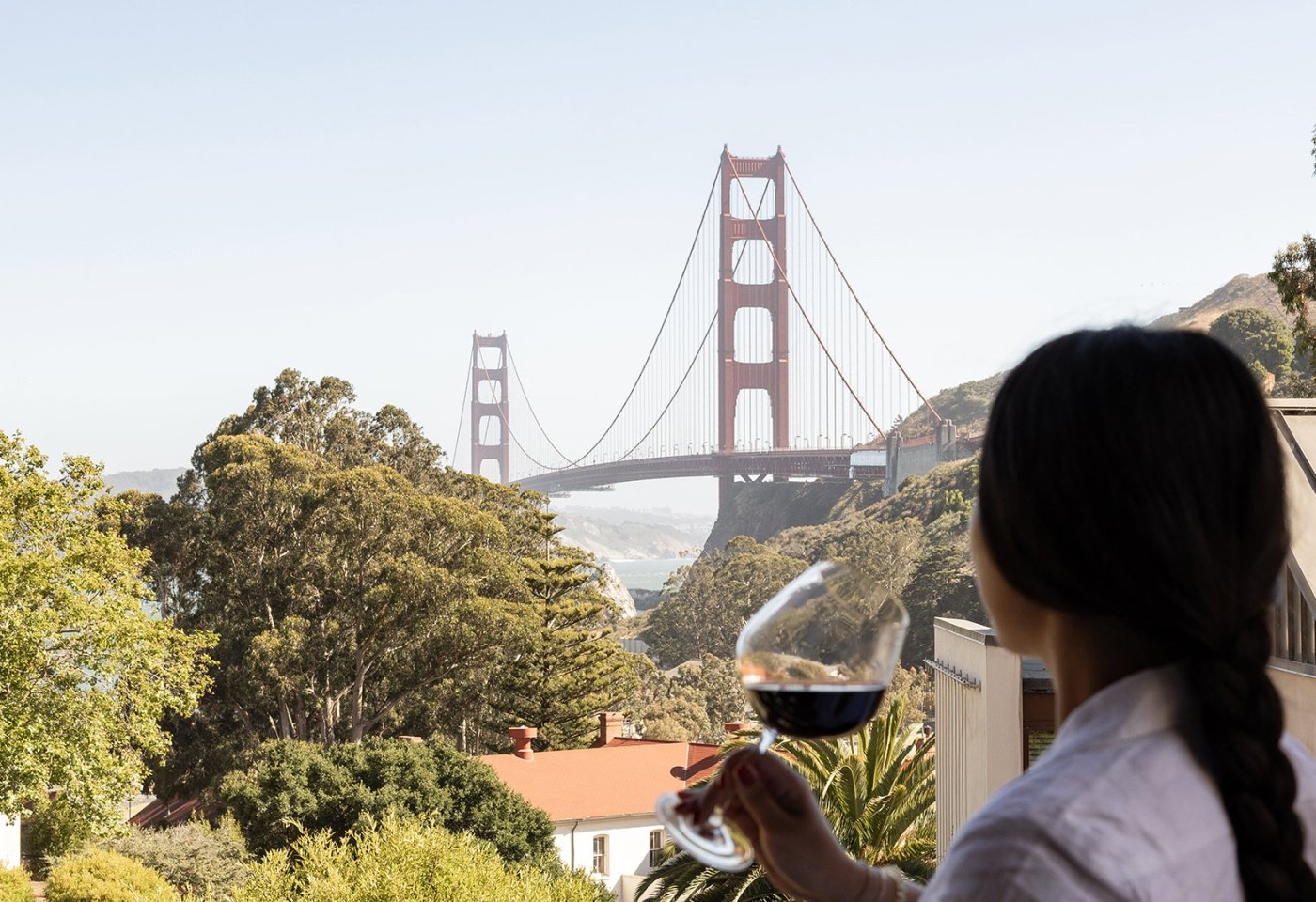 woman with glass of wine overlooking the golden gate bridge