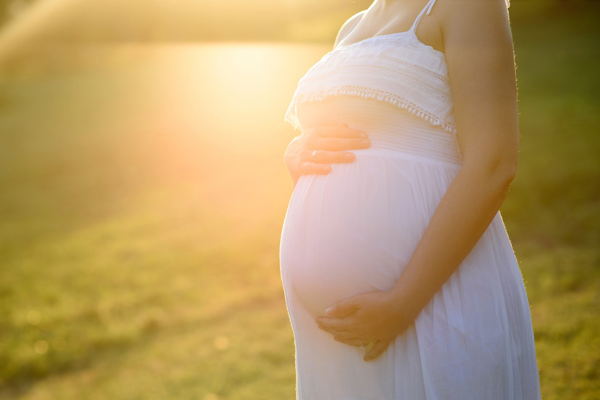 pregnant woman holding her belly.