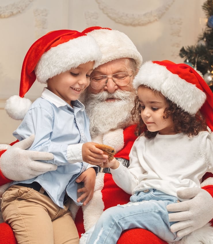 two kids sitting on santa claus' lap