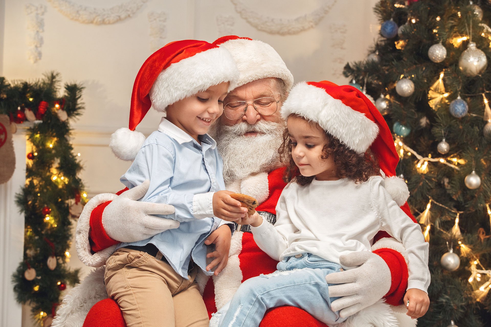 two kids sitting on santa claus' lap