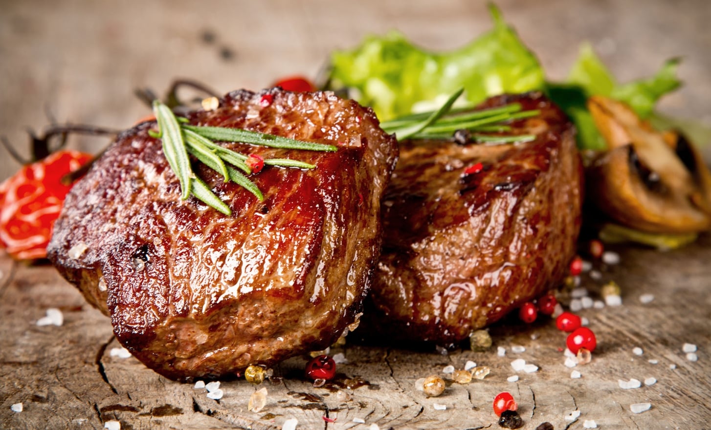 Seared steaks with fresh thyme, salt, and peppercorns