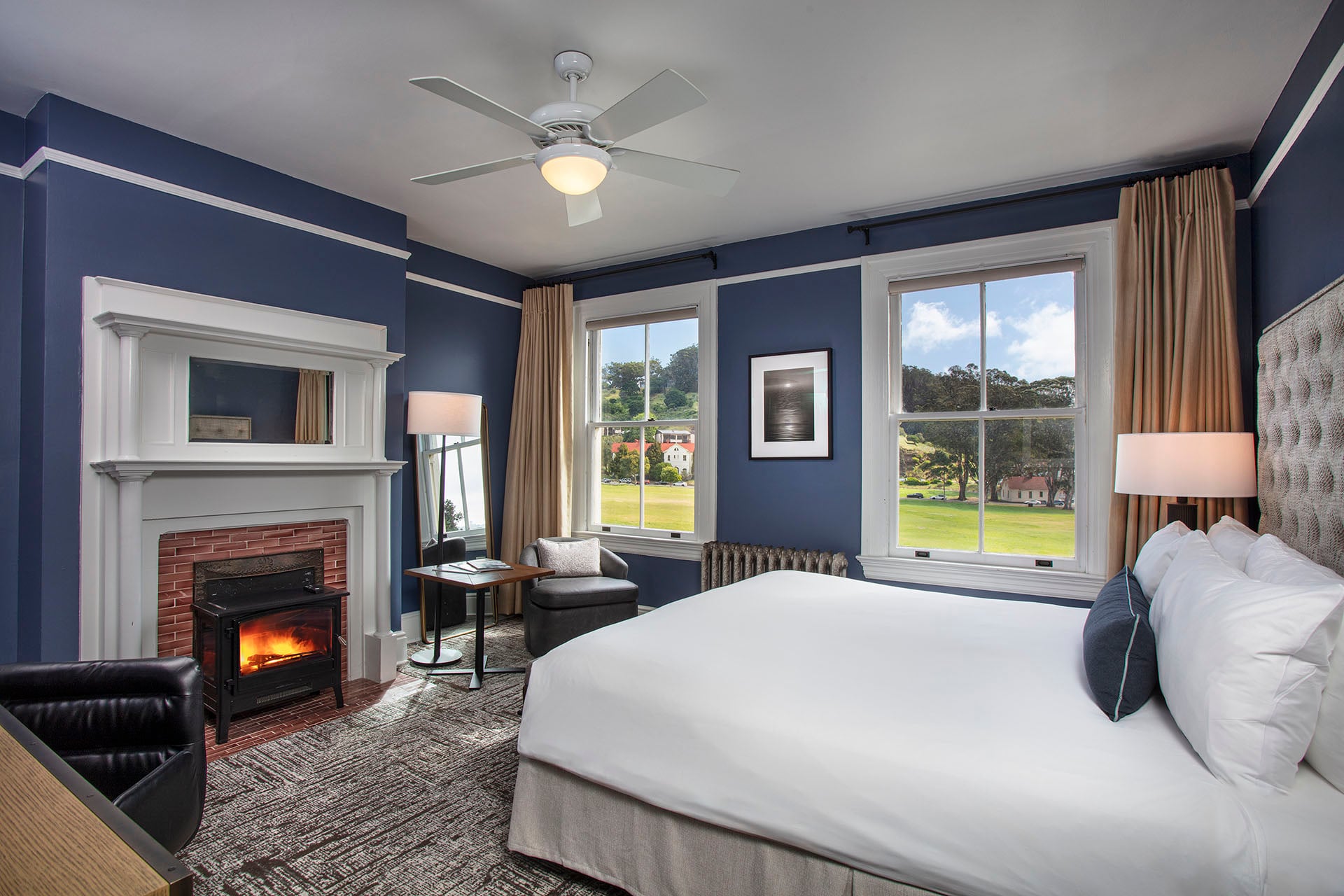 Historic King room with a fireplace, sitting chair, bed and views of the Cavallo Point property