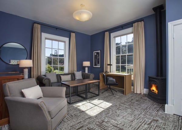 Sitting area with chair, couch, table, desk, fireplace and view of the Golden Gate Bridge