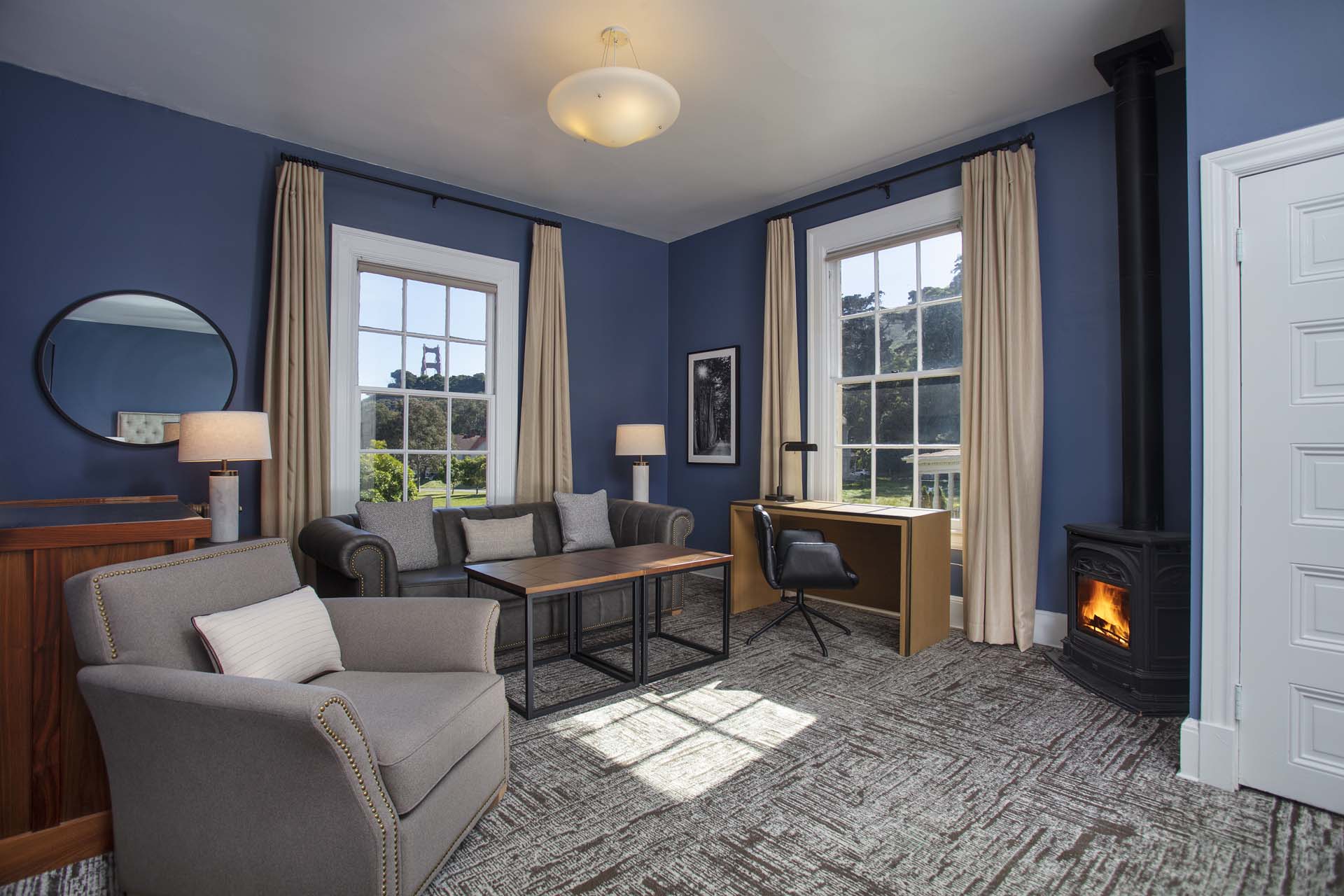 Sitting area with chair, couch, table, desk, fireplace and view of the Golden Gate Bridge