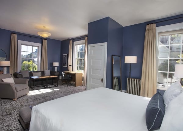 Room with King bed, chair, couch, table and desk
