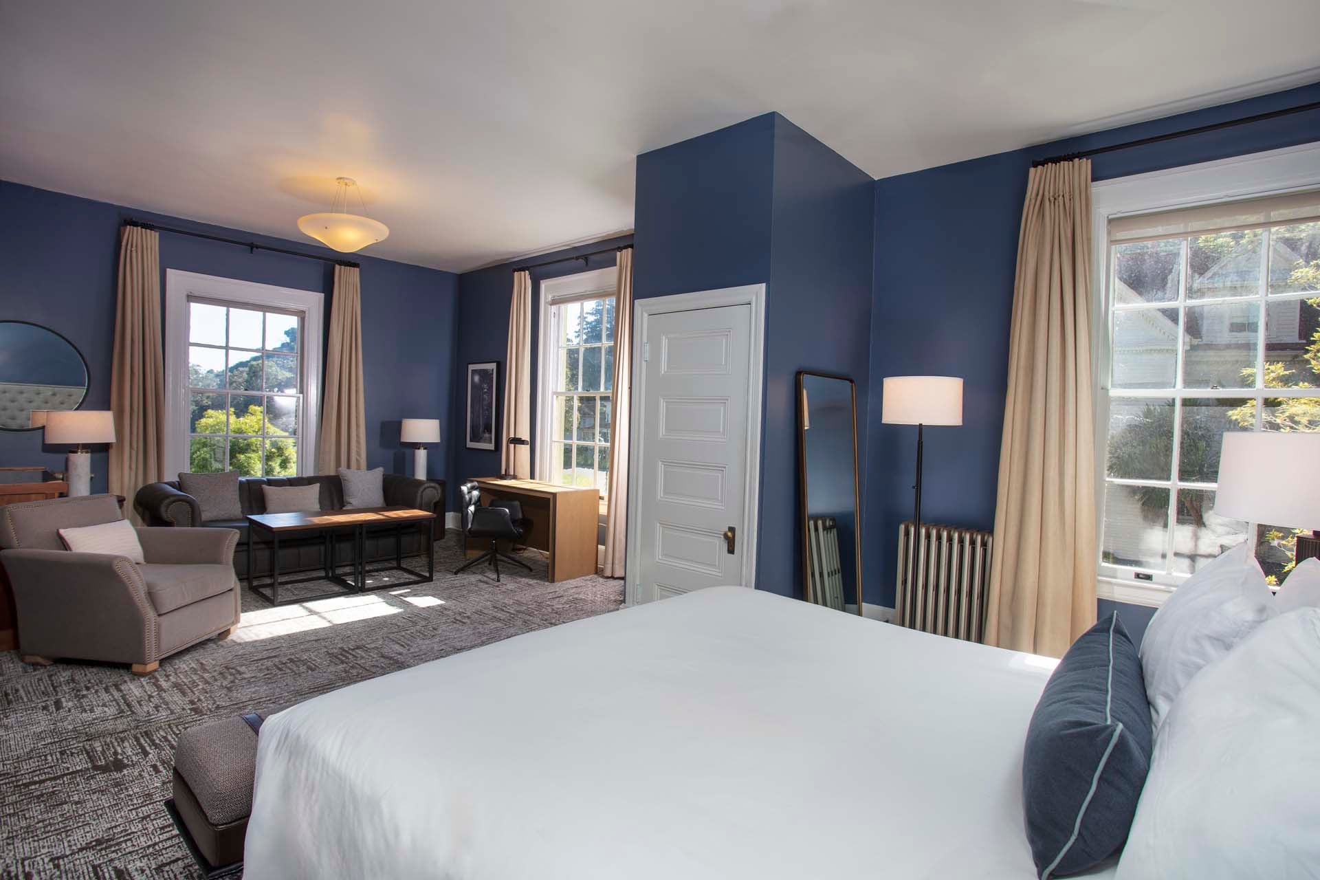 Room with King bed, chair, couch, table and desk
