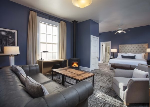 Historic room with couch, table, chair, desk, King bed and door into the bathroom