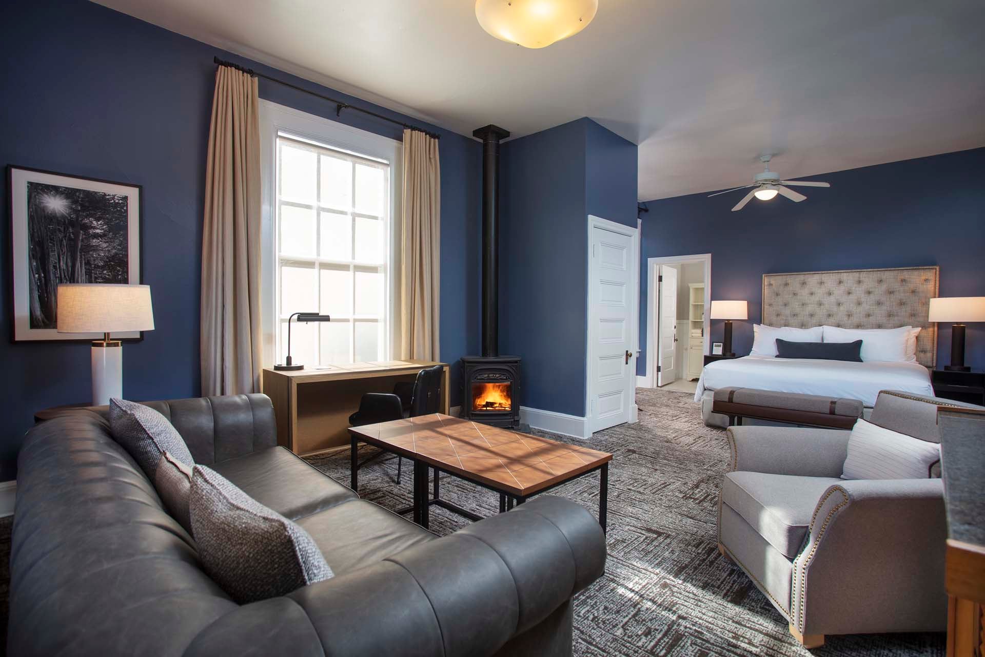 Historic room with couch, table, chair, desk, King bed and door into the bathroom