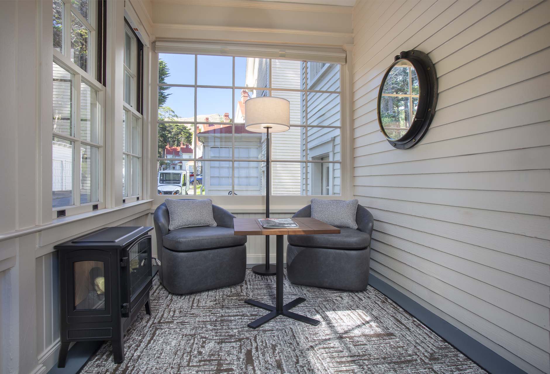 Covered seating area with two chairs, a table and an electric fireplace